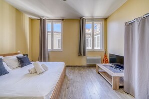 A hotel room with a bed, a desk, and two windows with curtains. - LE RICHELIEU - Magnifique duplex avec une vue Incroyable (Bordeaux)