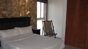 Une chambre à coucher avec un lit, une chaise, une fenêtre et une armoire.