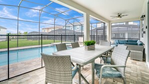 A covered patio with a pool, wicker furniture, and a view of neighboring houses. - Private Splash Pool • Disney Room • Game Room • Near Disney • Resort (Kissimmee)