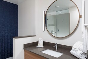 A modern bathroom with a large mirror, a sink, and a towel rack. - Fairfield Inn & Suites by Marriott Atlanta Marietta (Marietta)