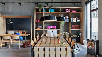 Un interior moderno con una mesa de comedor de madera, sillas, una estantería y una maleta.