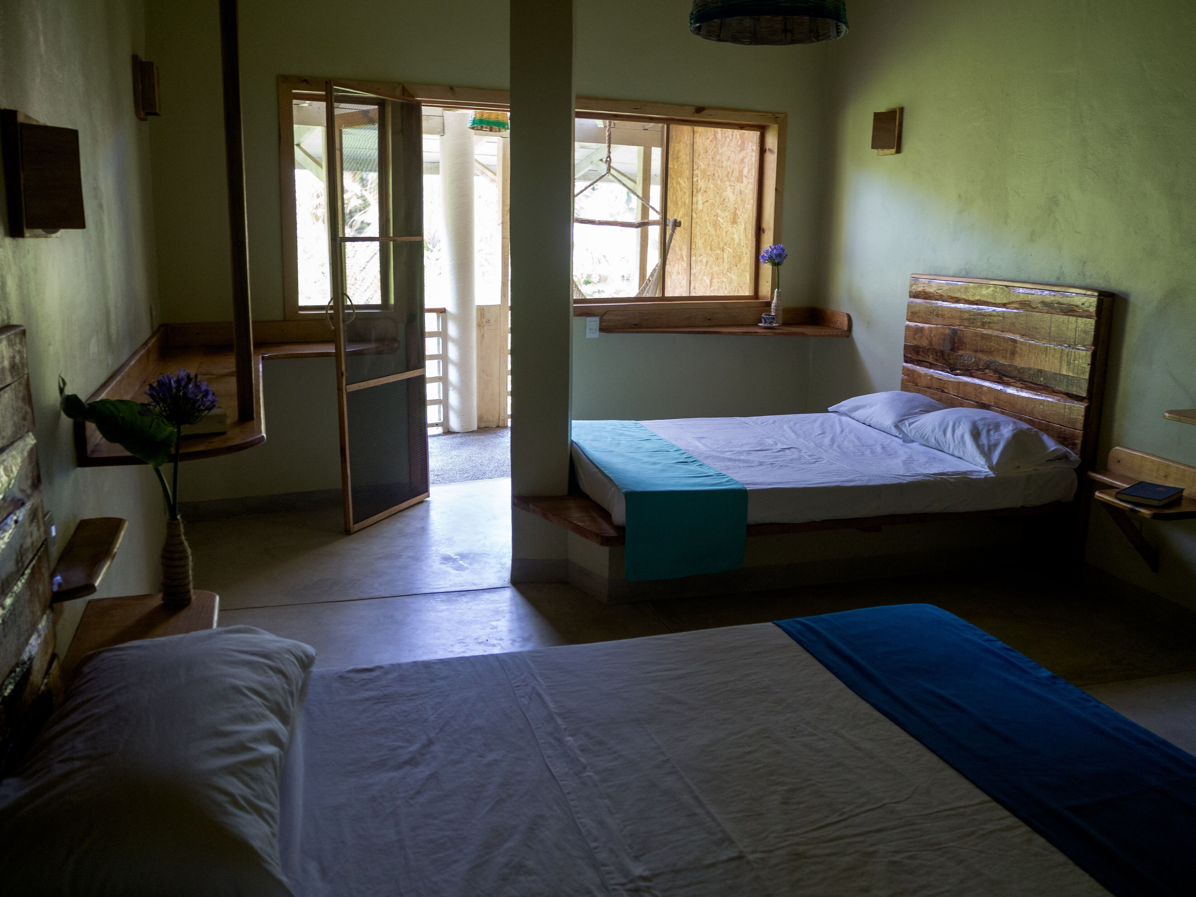 A room with two beds, a window with a view, and a door leading outside.
