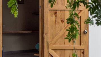 Una puerta de madera con un diseño sencillo, un picaporte metálico y un candado a la vista.