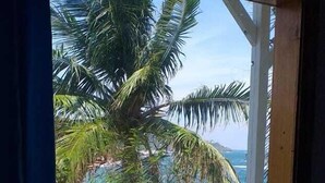 Una ventana con vista a una playa y palmeras.