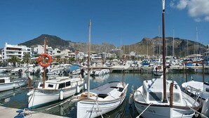 A marina with several boats docked, a lifebuoy, and buildings in the background. - 3 Bedrooms, 2 bathrooms, enbeded into the natural mediterranean surrounding. (Pollença)