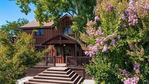 A wooden house with a porch and steps leading to the entrance.