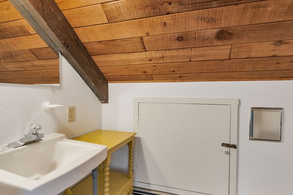 A bathroom with a wooden ceiling, a white sink, and a yellow vanity. - Spacious Home on the Loop in Chatham (Chatham)