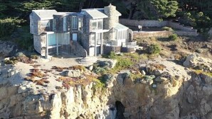A stone house with multiple levels and large windows, situated on a rocky cliff. - Breathtaking Ocean Front Retreat • Sonoma Coast • Timber Cove • Jenner (Jenner)