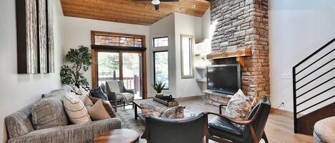 A modern living room with a fireplace, seating area, and a television.
