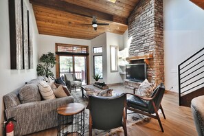 Una sala de estar moderna con chimenea, zona de estar y televisor.