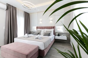 A modern bedroom with a large bed, a bedside table, a nightstand, and a large window with curtains.