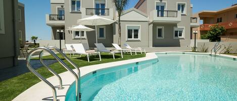 Piscine extérieure en saison, parasols, chaises longues