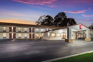 A motel with a two-story structure, a covered entrance, and a parking lot. - Red Roof Inn St George, SC (St. George)