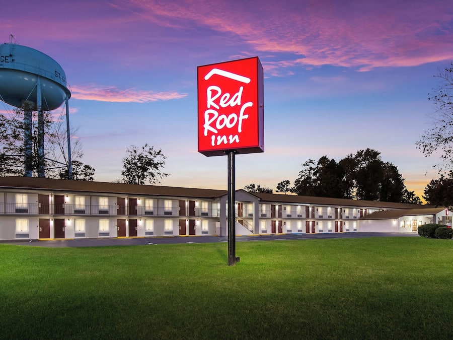 Een Red Roof Inn met een grote watertoren op de achtergrond.