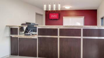 Un espace d’accueil doté d’un téléviseur à écran plat affichant le message « Wi-Fi gratuit dans toutes les chambres » et d’un comptoir avec une machine à café.