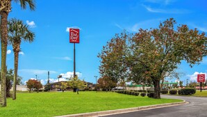 A Red Roof Inn with a clear sky, a well-maintained lawn, and a parking lot. - Red Roof Inn St George, SC (St. George)