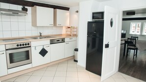 Una cocina moderna con armarios blancos, electrodomésticos de acero inoxidable y encimera de madera.