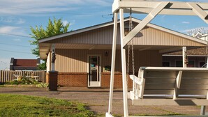 A building with a porch, a swing set, and a sign that reads "Quattro H".