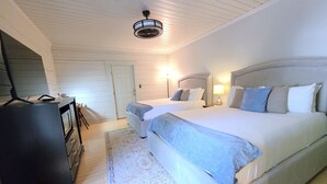 A bedroom with two beds, a ceiling fan, a desk, and a television. - Deluxe Room Two Queen Beds (Dahlonega)