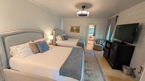 A bedroom with two beds, a TV, and a dresser. - Deluxe Room Two Queen Beds (Dahlonega)