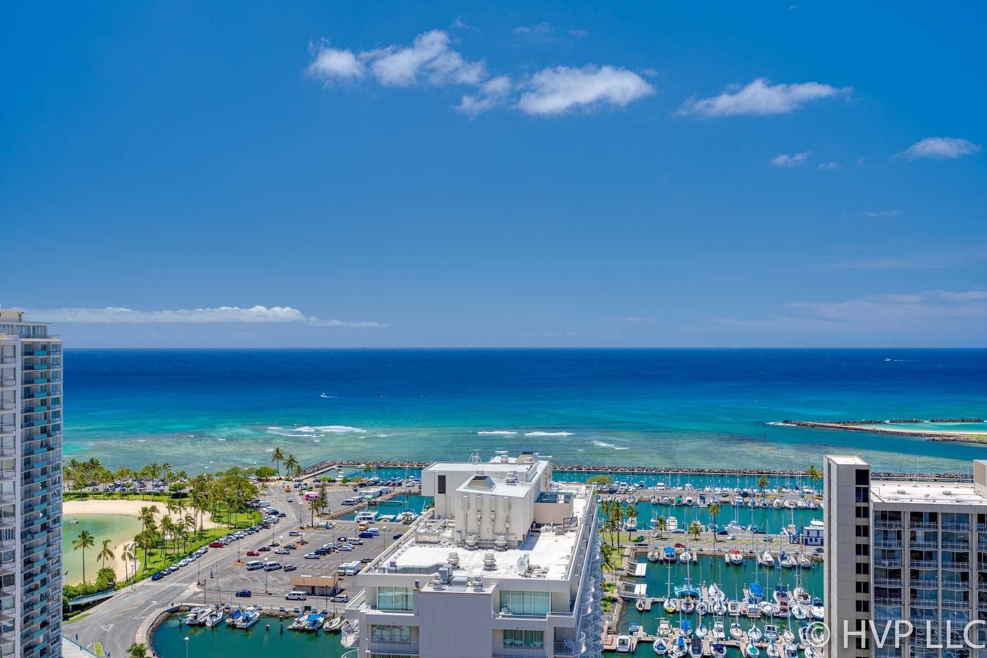 A high-rise hotel with a marina and ocean view.