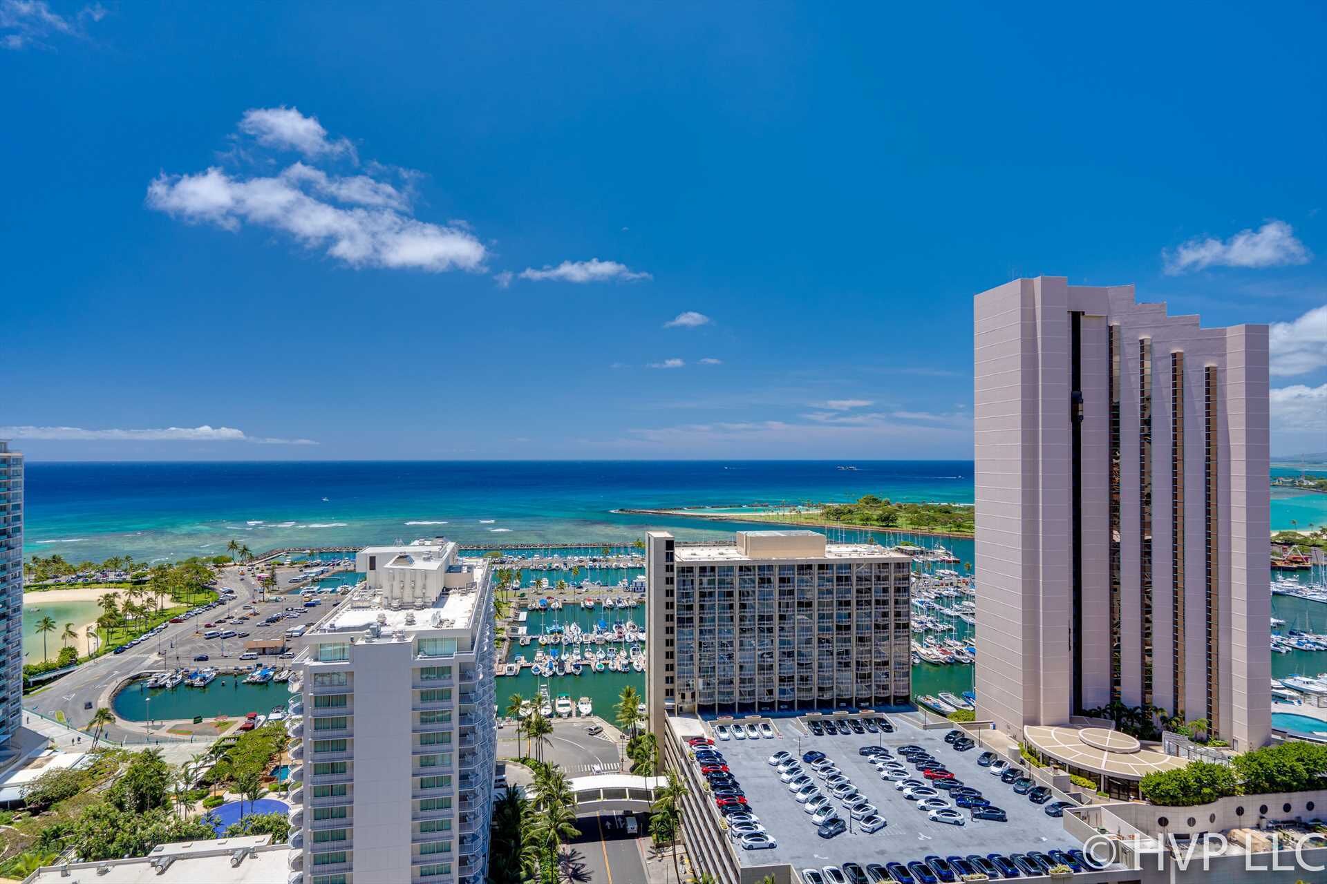 Un hotel di grandi dimensioni con un porto turistico e vista sull'oceano.