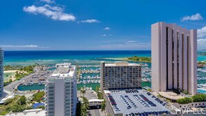 A high-rise hotel with a marina and ocean view.