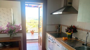 A kitchen with a dishwasher, sink, and a window overlooking a balcony. - "Apartamento Amanecer "Vista al Campo, Golf, Piscinas, Playas - Cerca del Algarve (Ayamonte)