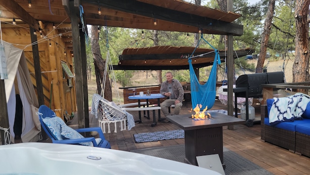 An outdoor patio with a hot tub, seating areas, and a barbecue grill. - BlueBird Nest 2.0, hot tub! Sibley double bell on huge deck!covered kitchen/bath (Hot Springs)