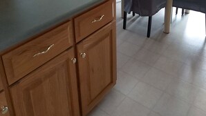 A modern kitchen with wooden cabinets and a dining area with a table and chairs. - The Big Happy Place (Fergus)