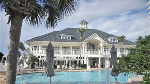 Ein großes Resort mit Swimmingpool, Liegestühlen und Sonnenschirmen.