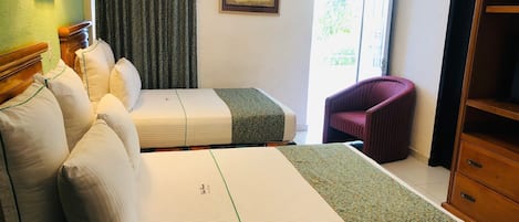 Habitación de hotel con dos camas, una silla, un armario, un cuadro y una ventana con cortinas.