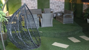 A hanging chair, wicker furniture, and artificial grass. - Laylati Al Yarmouk (Riyadh)