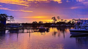 A marina with boats docked, calm water reflecting the sky, and a dock extending into the water. - BOATING LOVERS PARADISE! Enjoy our STUNNING 3 bed/3bath Orange Beach Bayou Condo (Orange Beach)