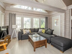 A modern living room with a sectional sofa, a coffee table, and a television. - Villa valo by Interhome (Lieksa)