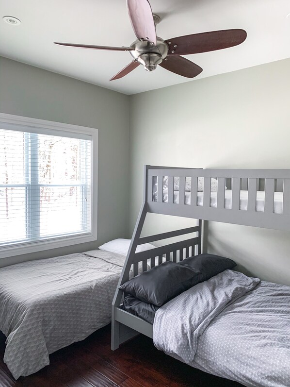 A bedroom with two bunk beds, a ceiling fan, and a window with blinds. - WATERFRONT COTTAGE in Muskoka (Gravenhurst)