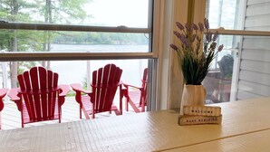 A wooden table with a welcome sign and a vase of flowers.