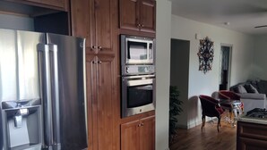 A modern kitchen with stainless steel appliances, wooden cabinets, and a granite countertop. - Get away from the hustle and bustle in an outdoor paradise! (Saratoga)