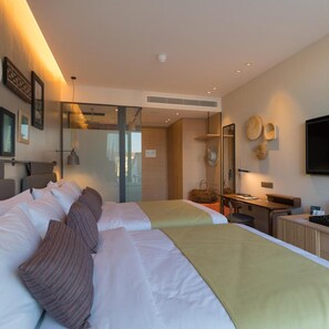A hotel room with two beds, a desk, a chair, a TV, and a mirror. - Indigo Hotel - Adults Only (Larnaca)