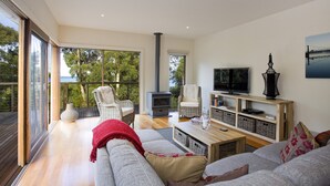 A spacious living area with a large sofa, a television, and a fireplace.