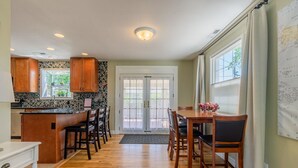 A kitchen with wooden cabinets, a central island, and a dining area with a table and chairs. - 4-bedroom vacation home just 15 minutes to Columbia River (Richland)