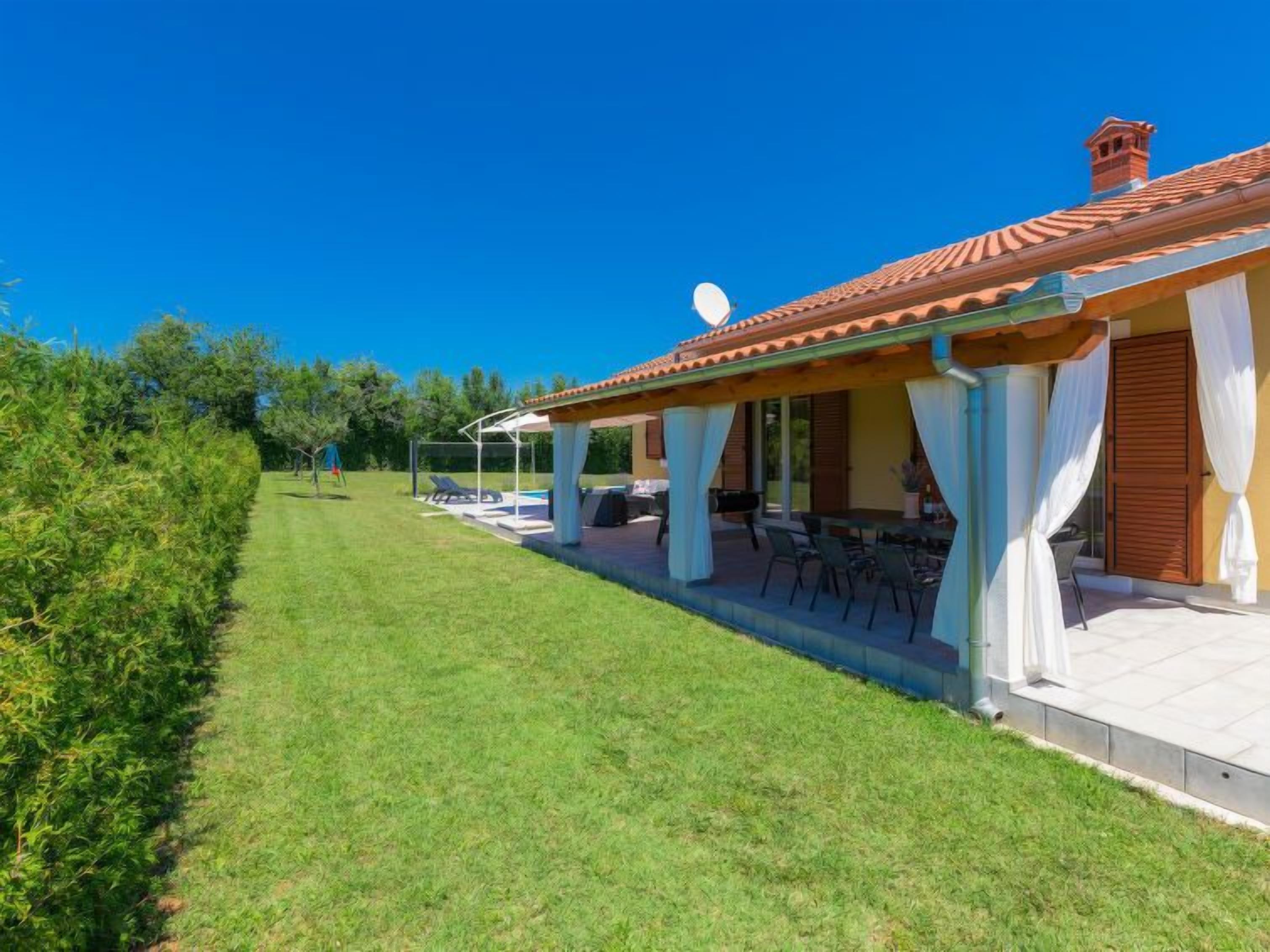 Une maison dotée d’un patio couvert, d’un espace salon extérieur et d’une piscine.