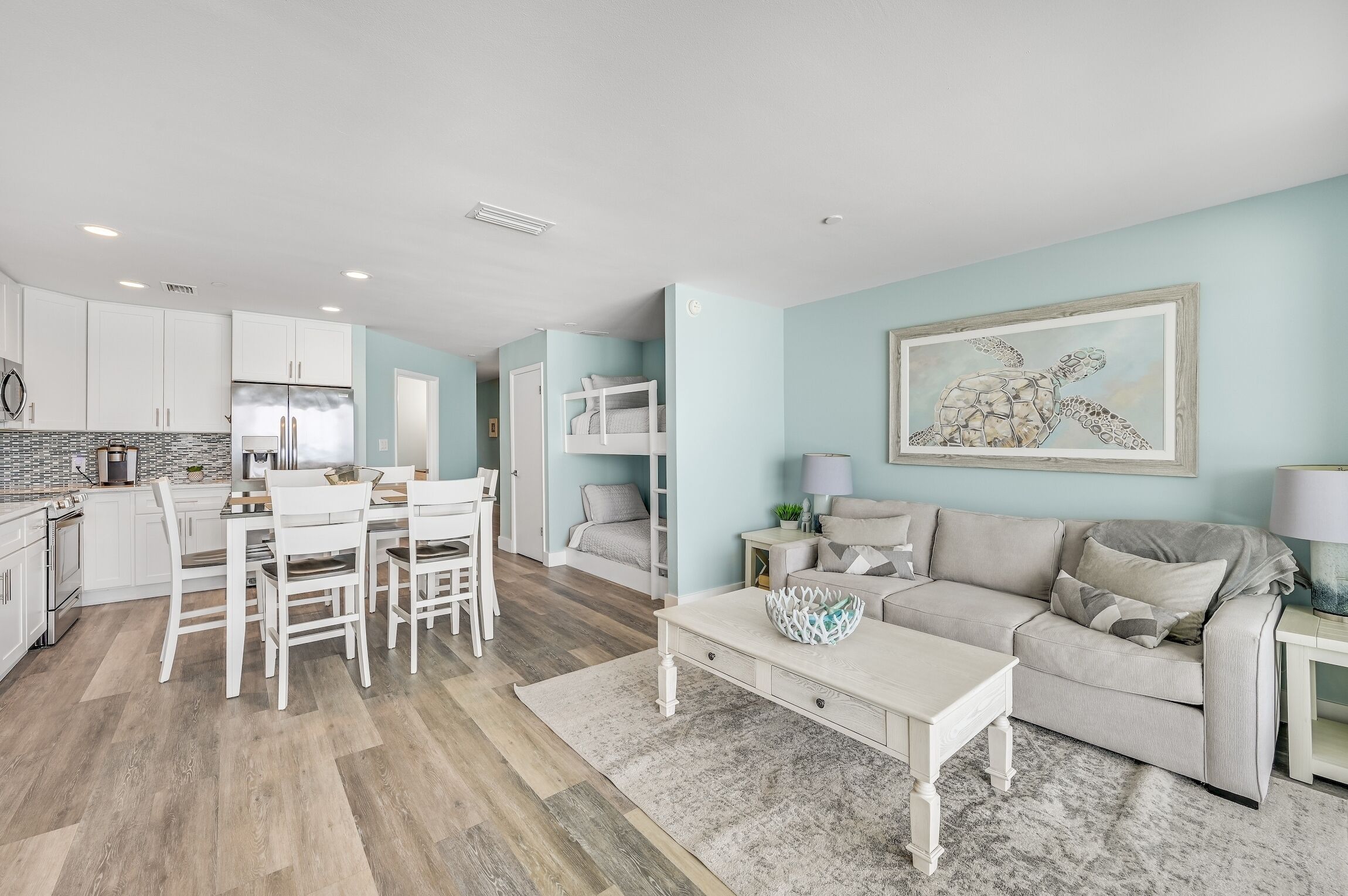 A modern living room with a sofa, coffee table, and a painting of a sea turtle.