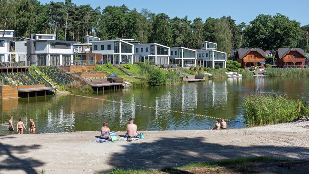 A lakeside resort with modern cabins, a sandy beach, and a calm lake. - Comfortable Chalet Near Brunssummerheide (Brunssum)
