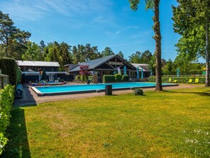Een zwembadgedeelte met een gebouw op de achtergrond, genaamd "De Houtzagerij".