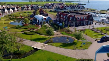 A coastal town with traditional architecture, a marina, and wind turbines.