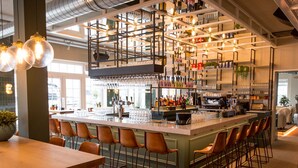 A bar area with a long counter, multiple stools, and a variety of bottles and glasses on shelves. - Holiday Home on the Markermeer Near Amsterdam (Uitdam)
