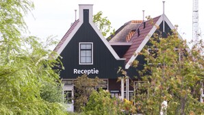 A black building with a sign reading "Receptie" in front. - Holiday Home on the Markermeer Near Amsterdam (Uitdam)