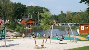 A lakeside park with swings and picnic tables. - Modern Holiday Home Near Brunssummerheide (Brunssum)