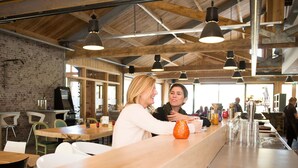 A modern restaurant with exposed wooden beams, a brick wall, and a long counter with multiple glasses. - Modern Chalet Near De Veluwe National Park (Otterlo)